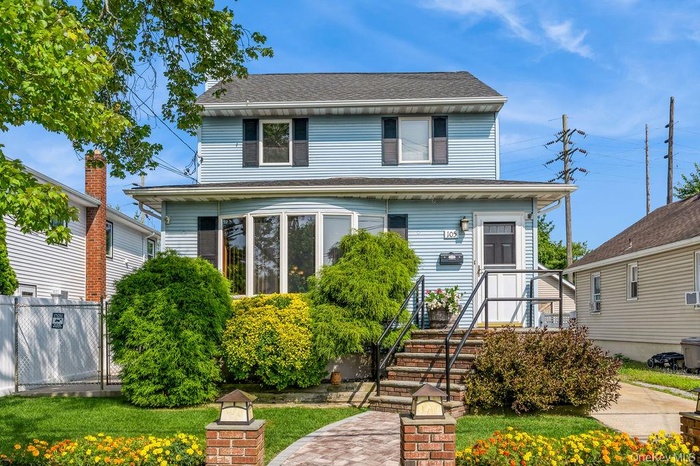 American foursquare style home with a shingled roof and a front yard