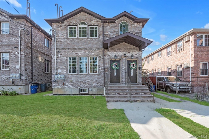 View of front facade featuring brick siding and a front yard