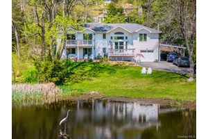 Welcome to this stunning High Ranch summer weekend vacation home in Huntington Bay, overlooking the exclusive 1 acre Pond View with access to the Knollwood Beach community.