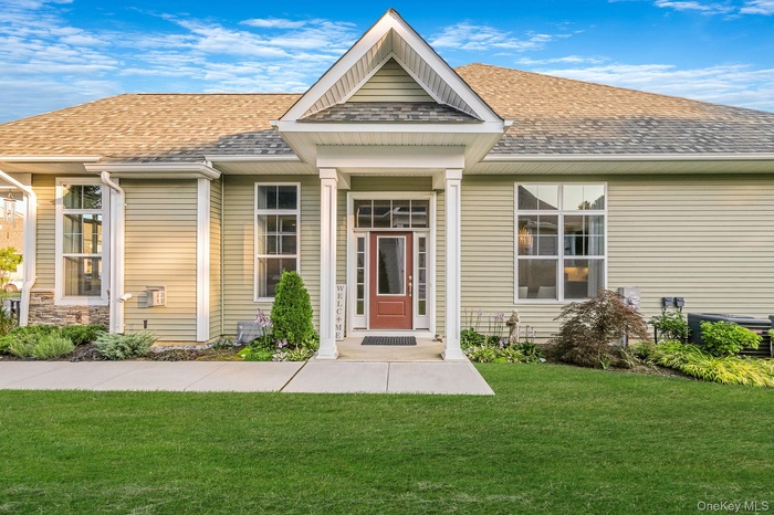 View of front facade with a shingled roof and a front yard
