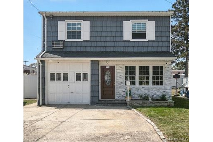 View of front of house with concrete driveway and a garage