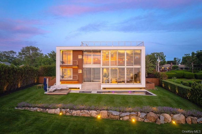 Back of house at dusk with a balcony