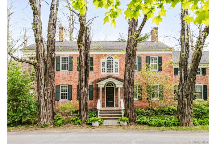 Colonial home with a chimney and brick siding
