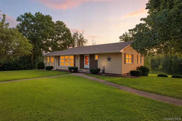 Ranch-style home featuring a front lawn and a chimney