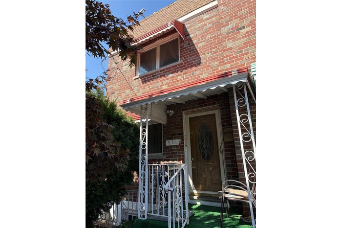 Doorway to property featuring brick siding and covered porch