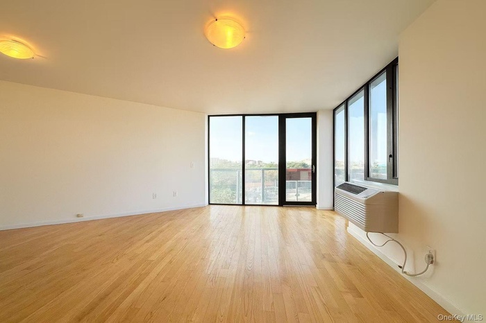 Spare room featuring a wall of windows and light wood-style flooring