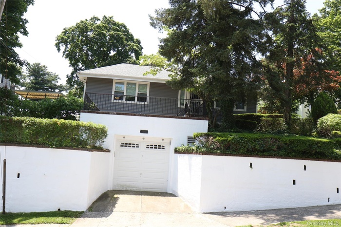 View of front of property featuring driveway, an attached garage, and stucco siding