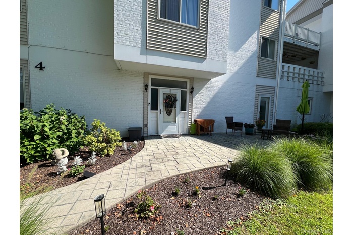 View of exterior entry with brick siding and a patio area