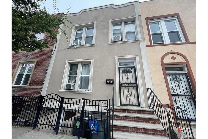 Townhome / multi-family property with a gate, stucco siding, cooling unit, and a fenced front yard