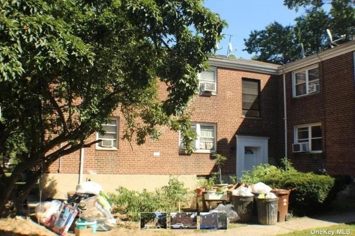 View of property featuring brick siding and cooling unit