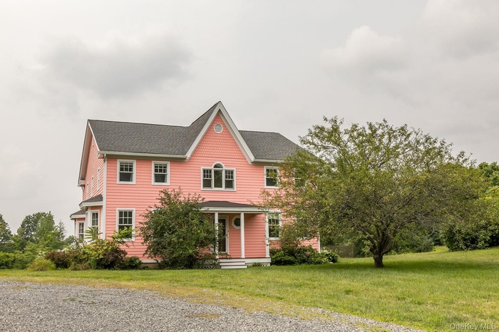 View of front of house featuring a shingled roof, a front lawn, and a porch