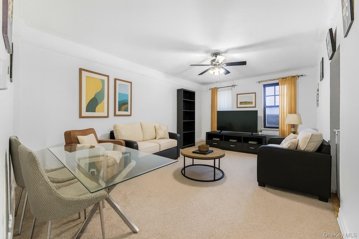Living room with light carpet and a ceiling fan