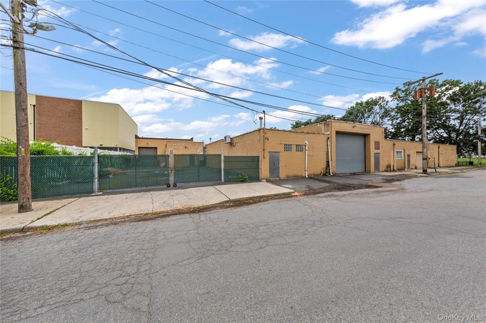 View of building exterior featuring a fenced front yard and a garage