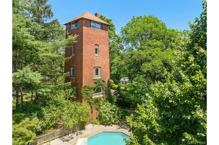 View of property exterior with a chimney and brick siding