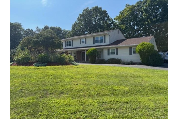 Traditional-style home with a front lawn and covered porch