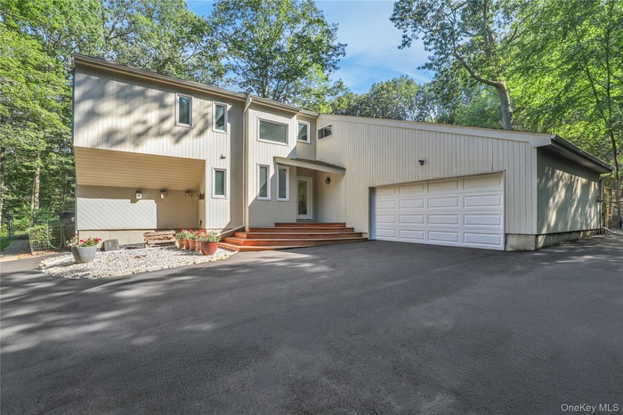 Mid-century home featuring an attached garage and driveway