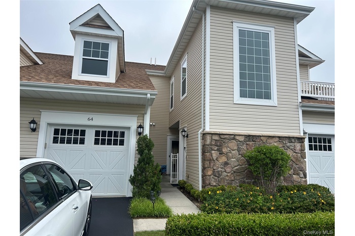 View of front of house with a shingled roof and stone siding