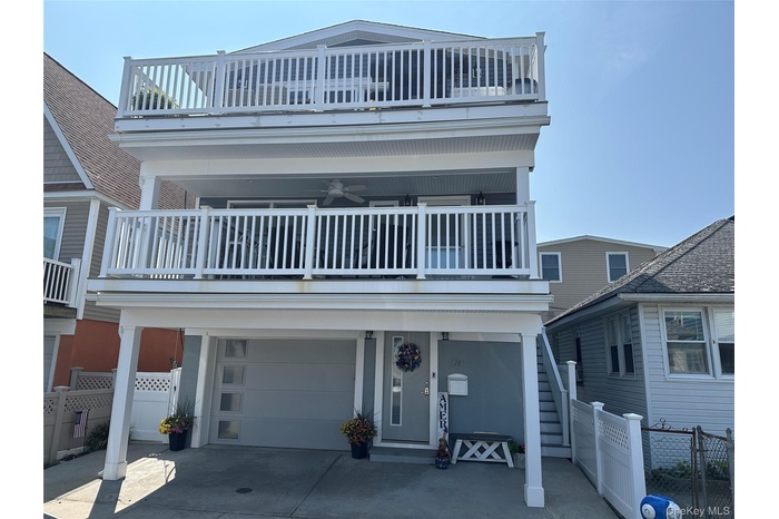 View of front of house with an attached garage, a balcony, and driveway