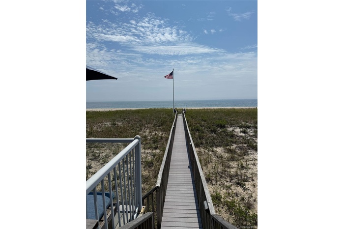 Surrounding community featuring view of water and beach