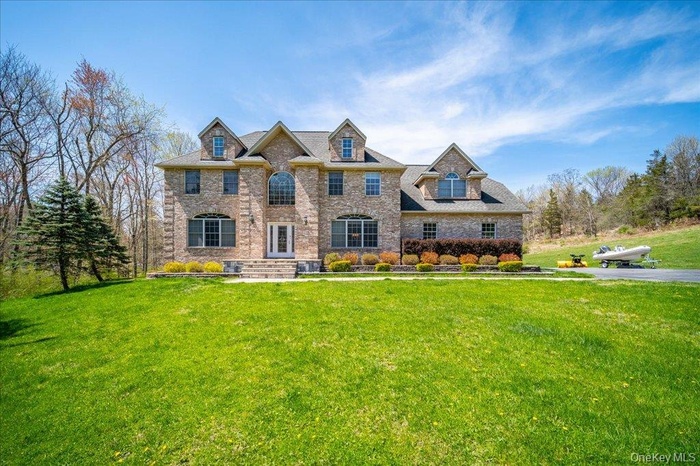 Welcome to your country dream home, featuring a brick facade, long wide driveway, and perfect views of nature.