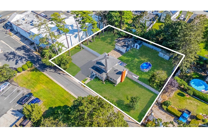 Aerial view of property and surrounding area featuring property parcel outlined