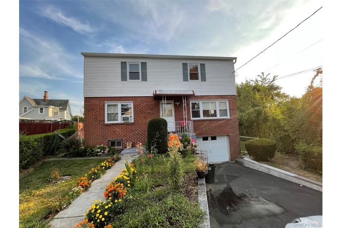 View of front of property with brick siding, asphalt driveway, and an attached garage