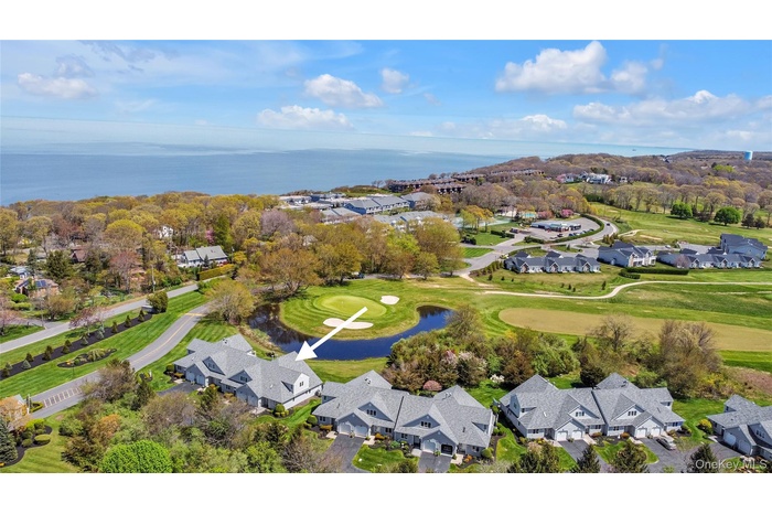 View of property location featuring nearby suburban area, a large body of water, and a golf course