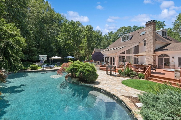 Heated gunite pool with a wooden deck and a patio area
