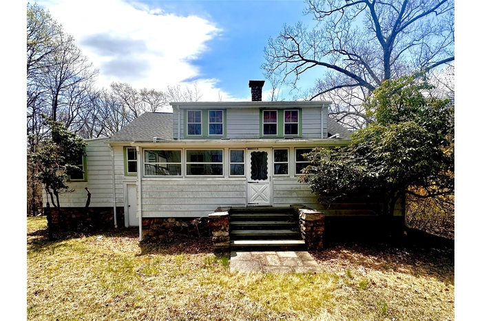 Rear view of house with a chimney, entry steps, and roof with shingles