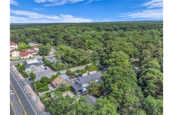 Aerial overview of property's location with a heavily wooded area