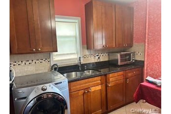 Laundry area featuring light tile patterned floors