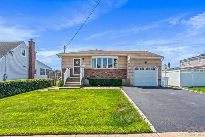 View of house featuring a garage, asphalt driveway, and brick siding