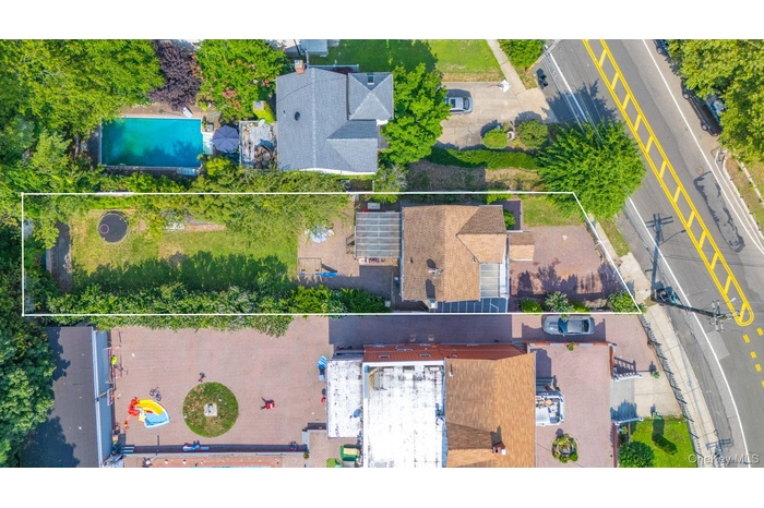 Aerial view of property and surrounding area with a pool area and property parcel outlined