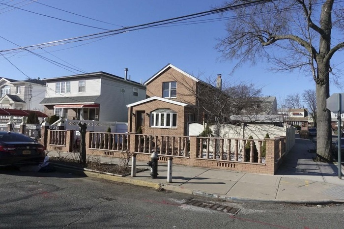 View of front of home with a fenced front yard and brick siding