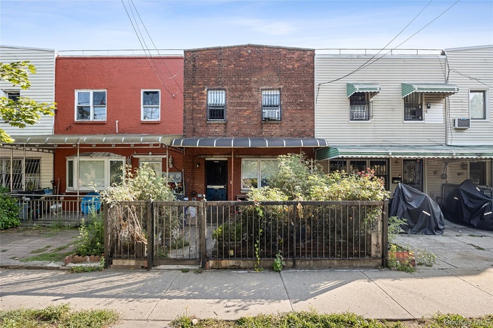 Traditional home with brick siding and a fenced front yard