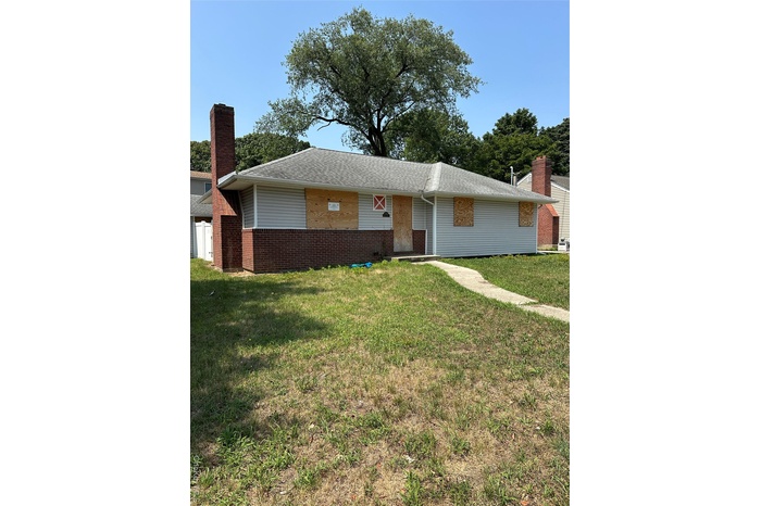 Ranch-style home with brick siding, a front yard, and roof with shingles