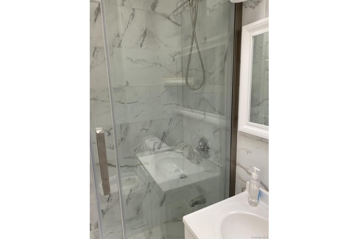 Full bathroom with vanity and a marble finish shower