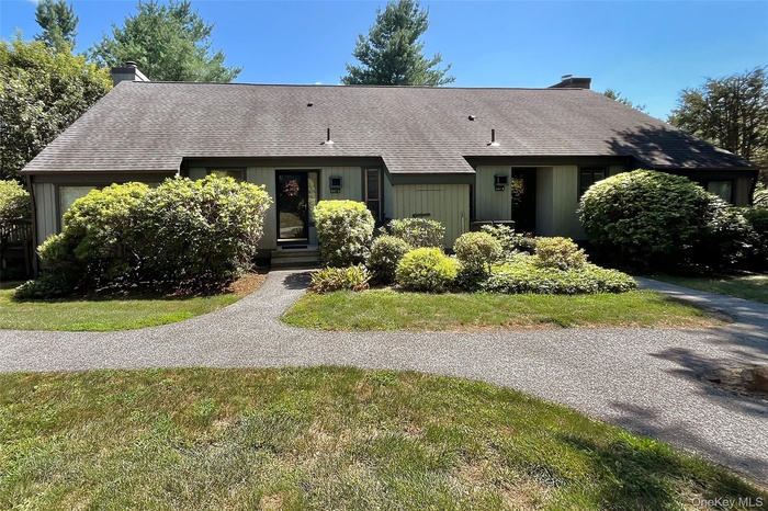 Ranch-style house featuring a chimney, roof with shingles, and a front lawn