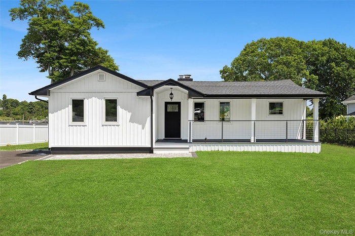 Modern inspired farmhouse with a shingled roof, covered porch, and a chimney