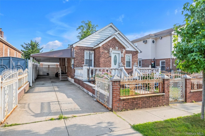View of front of house featuring brick siding, a fenced front yard, and a gate