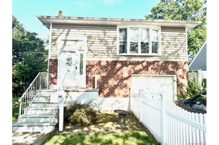 View of front facade featuring brick siding and a garage
