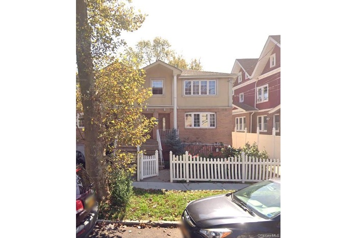 View of front of property with a fenced front yard, stucco siding, and brick siding