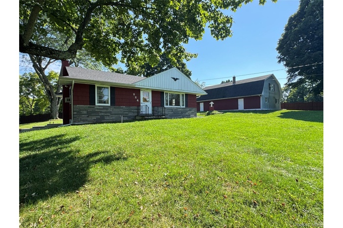 Ranch-style house with stone siding and a front lawn
