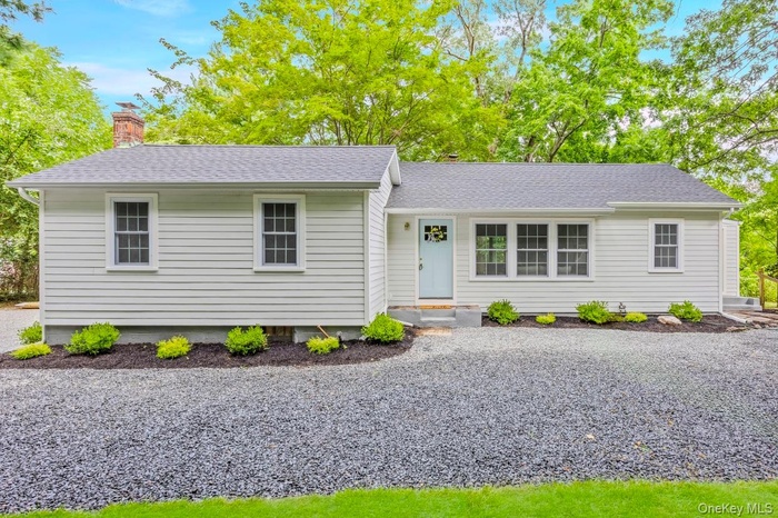 View of front of home featuring a shingled roof and a chimney