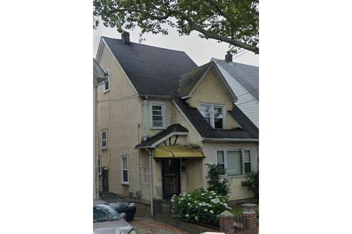 View of front of property with a shingled roof and a chimney