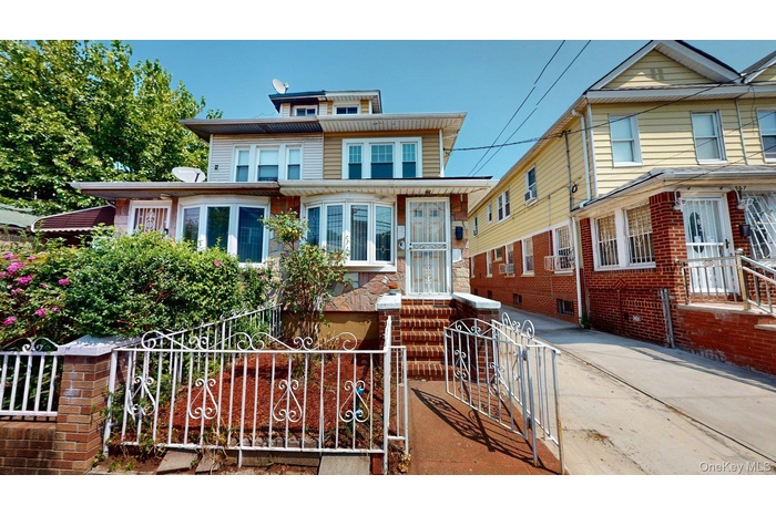 American foursquare style home featuring a fenced front yard, a gate, and concrete driveway