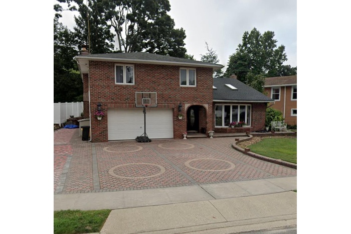 Traditional-style home with curved driveway, an attached garage, and brick siding