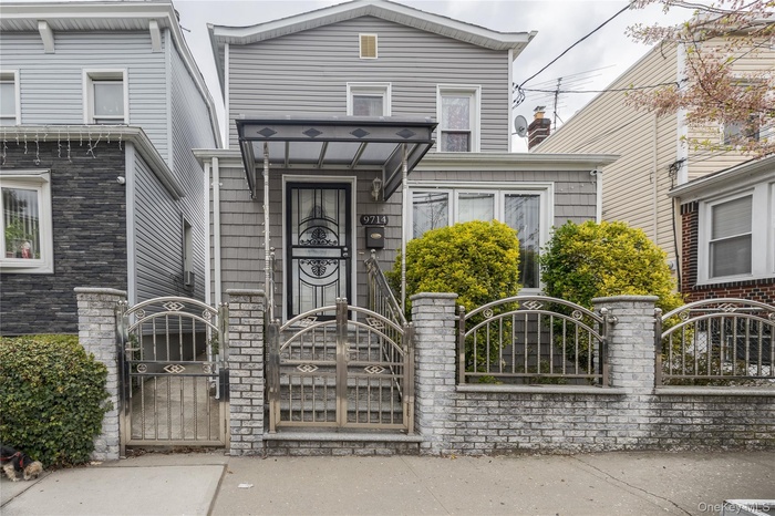 View of front of property with a fenced front yard and a gate