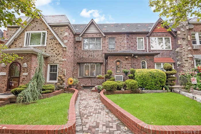 Tudor home with a high end roof, a front yard, and brick siding