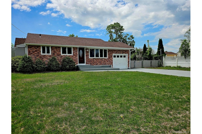 Ranch-style home featuring a garage and driveway